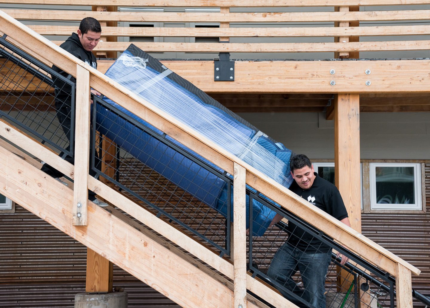 Double Diamond movers carefully carrying a protected item down stairs